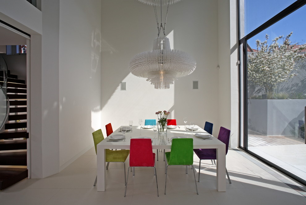 Разноцветные стулья у стола в интерьере столовой