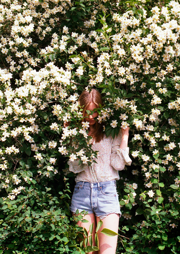 юная девушка весной на фоне цветущих кустов