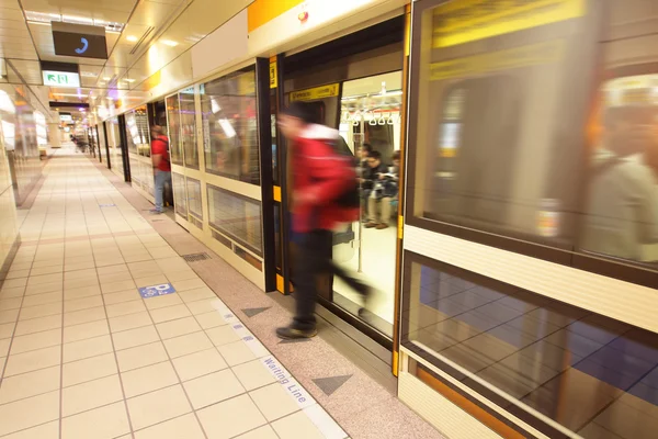 Перемещение выходя из поезда на станции метро — стоковое фото