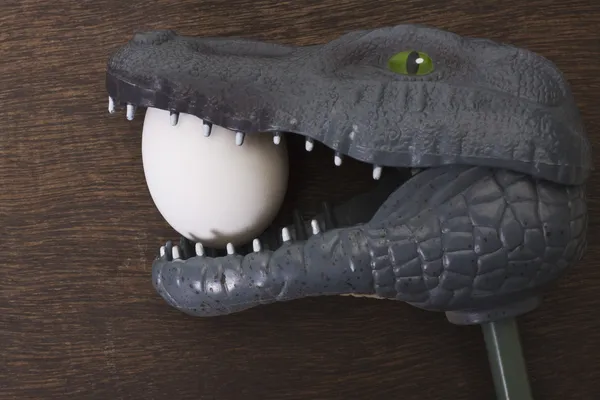 Игрушка Крокодил, держа яйцо в челюсть — стоковое фото