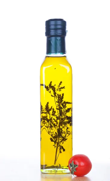 Оливковое масло в стеклянной бутылке с помидорами черри — стоковое фото