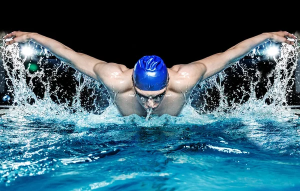 Мускулистые молодой человек в синей шапке в бассейне — стоковое фото