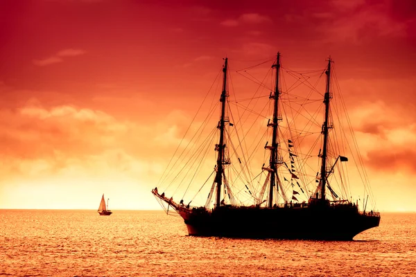 Талль корабль, плывущий в красном — стоковое фото