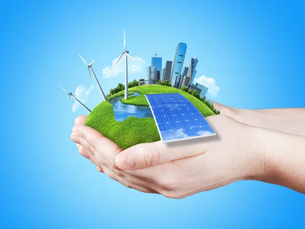 Руки, держа очистить зелёный луг с солнечной батареи блока, мельница ветрогенераторы и город небоскребов — стоковое фото