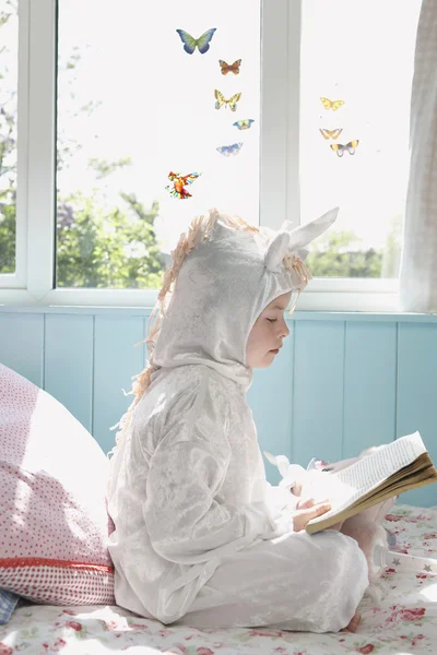 Девушка в костюме Единорог с книгой — стоковое фото