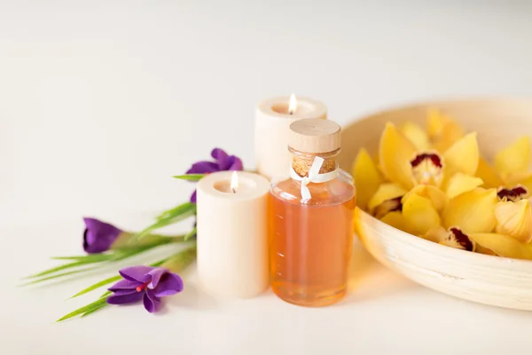 Цветы орхидеи в миску, масло, свечи и ирисы — стоковое фото