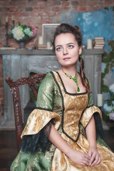 Красивая женщина в средневековом платье на стуле — стоковое фото