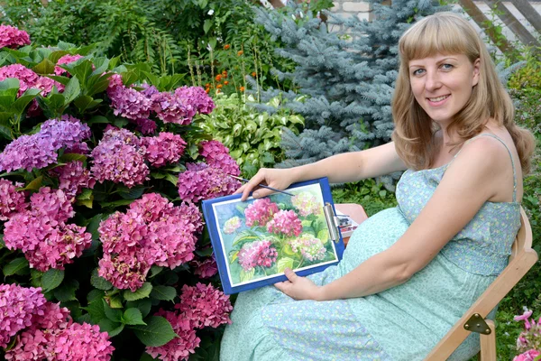 Молодых беременных женщин художник показывает рисунок цветущей h — стоковое фото