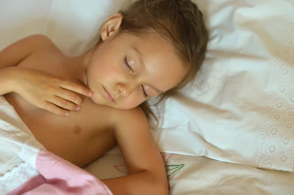 Спит маленькая девочка в кровати — стоковое фото