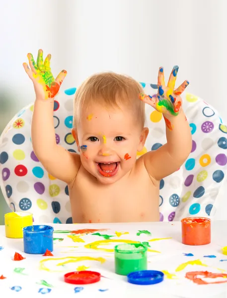 Счастливый ребенок рисует с цветными красками руки — стоковое фото