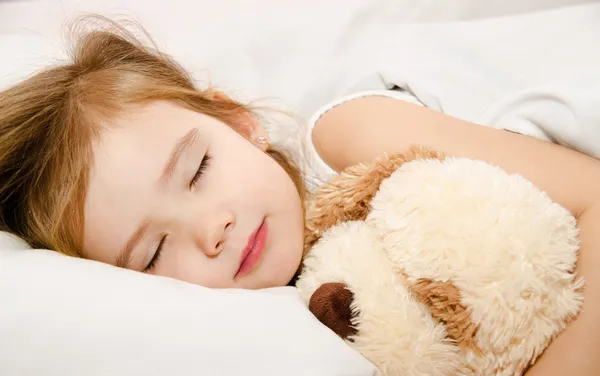 Восхитительная маленькая девочка, спящая в постели — стоковое фото