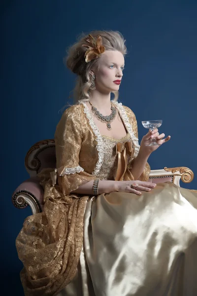 Ретро мода барокко женщины носили золотые платья. Холдинг вин гла — стоковое фото
