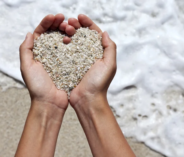 Мягкий сердце, формирование женской руки над пляжем — стоковое фото