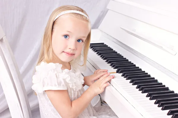 Маленькая девочка на фортепиано — стоковое фото