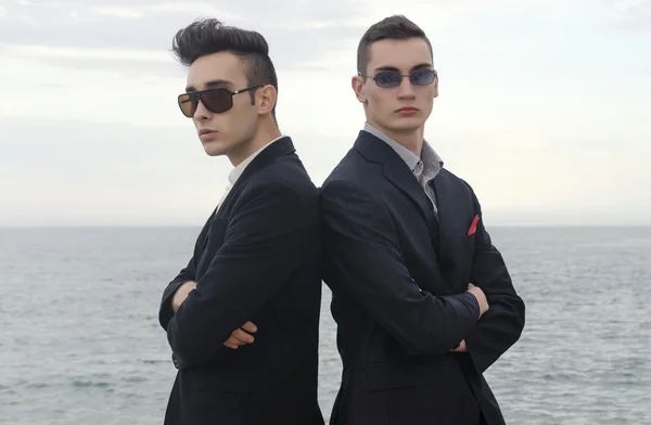 Два молодых бизнесмена позирует моды на пляже и насладиться их отпуска — стоковое фото