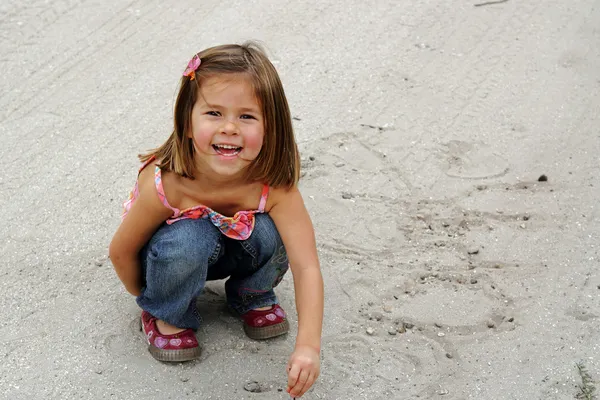 Девушка играет в песке — стоковое фото