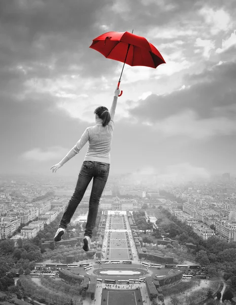 Молодая женщина с красным зонтиком, пролетел над Парижем — стоковое фото