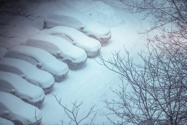Автомобили, покрытые снегом на автостоянке в жилом районе du — стоковое фото