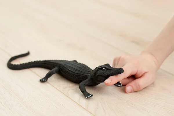 Игрушечный крокодил кусает руку — стоковое фото