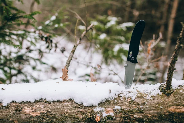 Острый pocketknife в снежном лесу — стоковое фото