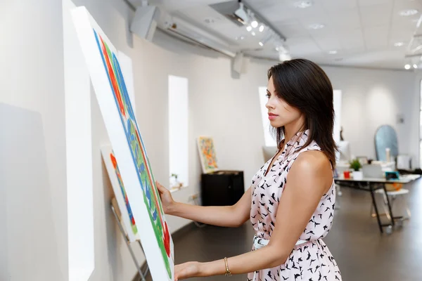 Молодая женщина кавказской, стоя в передней Арт Галерея картин — стоковое фото