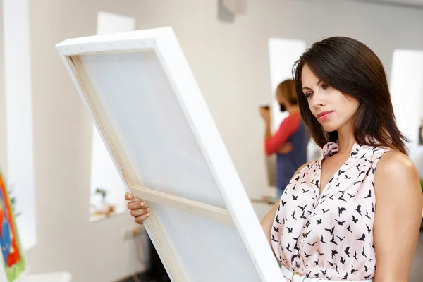Молодая женщина кавказской, стоя в передней Арт Галерея картин — стоковое фото