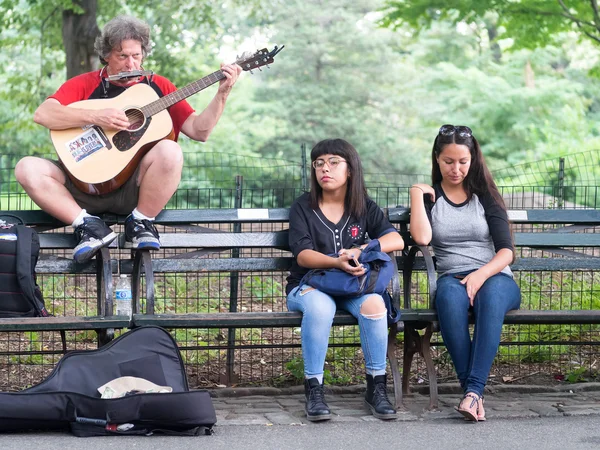 Улица исполнитель пел Джон Леннон песни на Strawberry Fields в Центральном парке, Нью-Йорк — стоковое фото