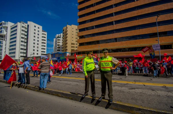 Два эквадорские полицейские одеты в форму надзорные протестующих маршируют в столице Кито против правительства президента Рафаэля Корреа — стоковое фото