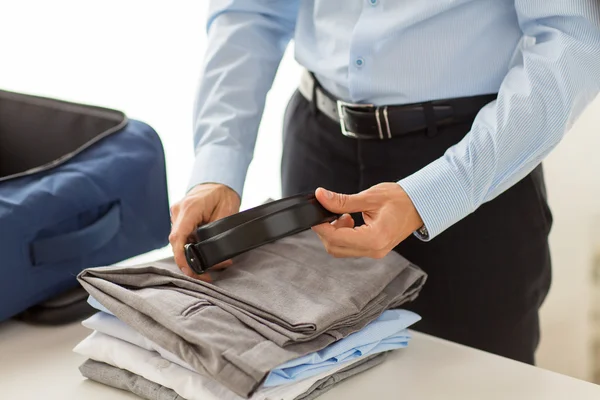 Бизнесмен, упаковывающий одежду в несессер — стоковое фото