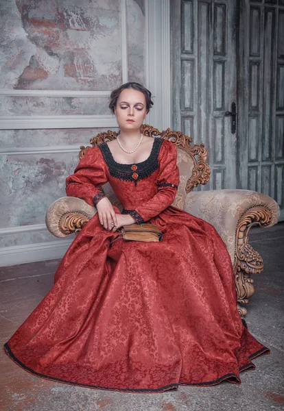 Красивая женщина в средневековом платье на кресле — стоковое фото