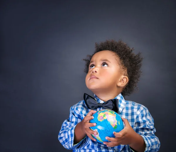 Маленький школьник с глобусом в руках — стоковое фото