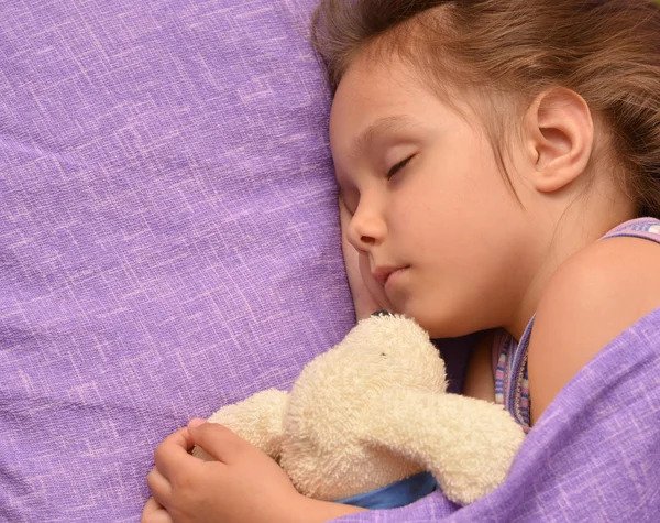 Маленькая девочка спит с игрушкой — стоковое фото