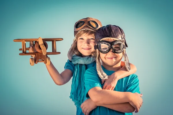 Счастливые дети, играющие с игрушечным самолетом — стоковое фото