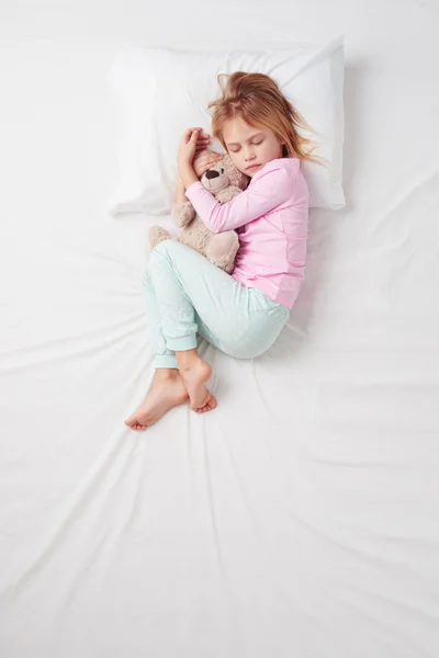 Вид сверху маленькая девочка спит с мишкой — стоковое фото