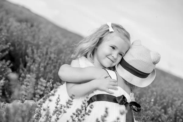Две маленьких девочки, обнимающие на лаванде — стоковое фото