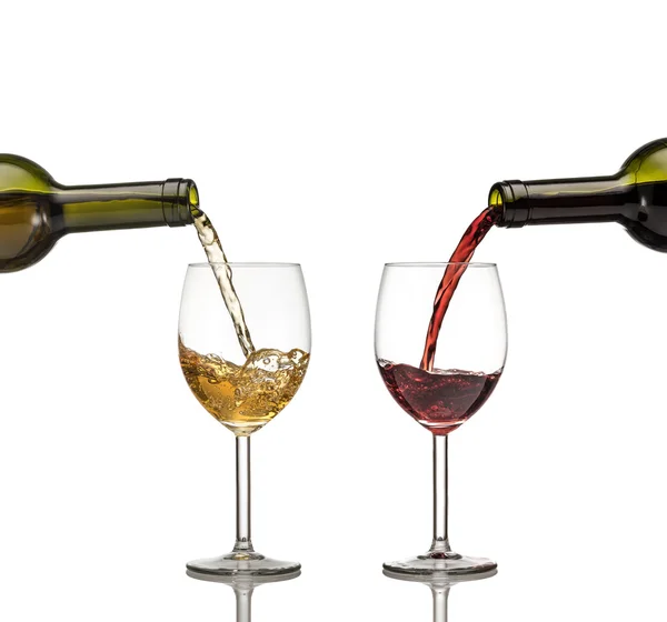 Красное и белое вино выливают в бокал вина на белом backgro — стоковое фото