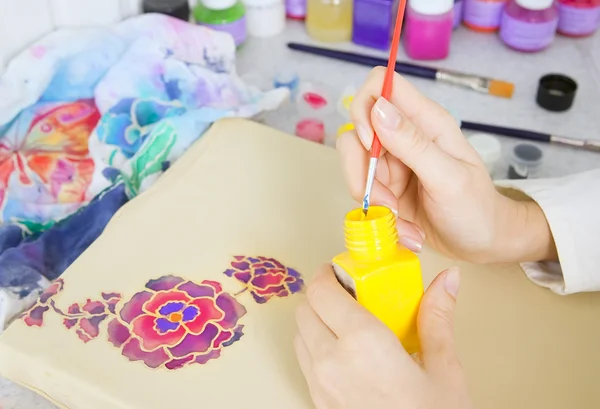 Процесс батика: художник подрисовывает ткань, живопись батика — стоковое фото