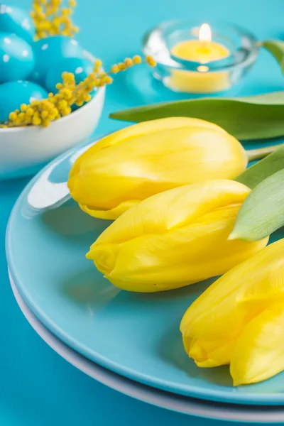 Сервировка стола Пасха с желтыми тюльпанами и яйца на синий backgro — стоковое фото