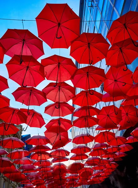 Красные зонты в воздухе — стоковое фото