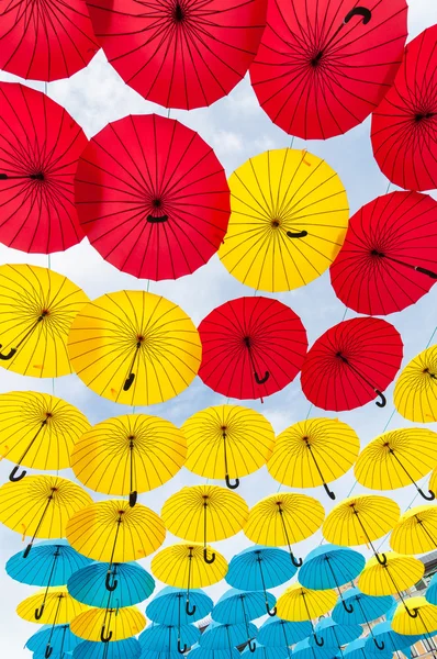 Многие открытия в небо зонтики дают гарантию, что дождя не будет испортить день. Красный, желтый и голубой зонтик. Киев, Украина — стоковое фото
