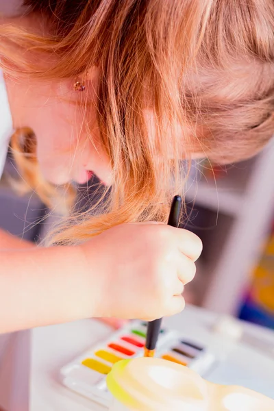 Красивая девочка рисует краски — стоковое фото