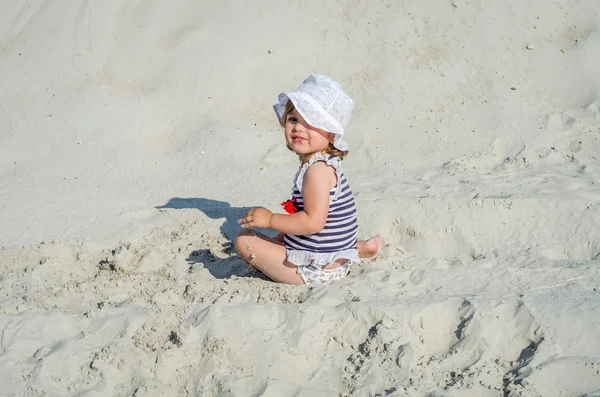 Очаровательная девушка малыш, детские футболки, купальный костюм и шляпа счастливый смех и играть в белый песок на пляже на берегу моря, яркий солнечный жаркий день на курорте во время праздников родителей — стоковое фото