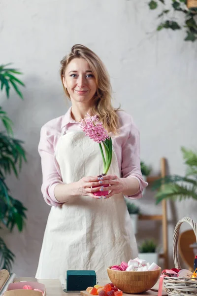 Изображение женщины флорист в фартук в комнате с цветами — стоковое фото