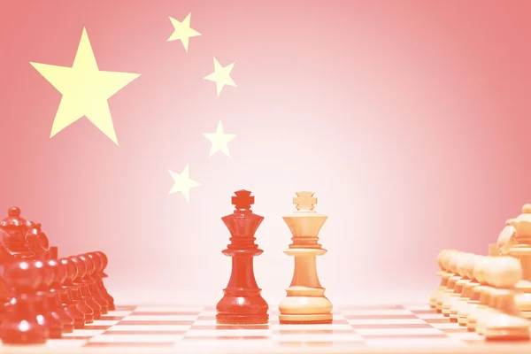 Шахматные фигуры против китайского флага — стоковое фото