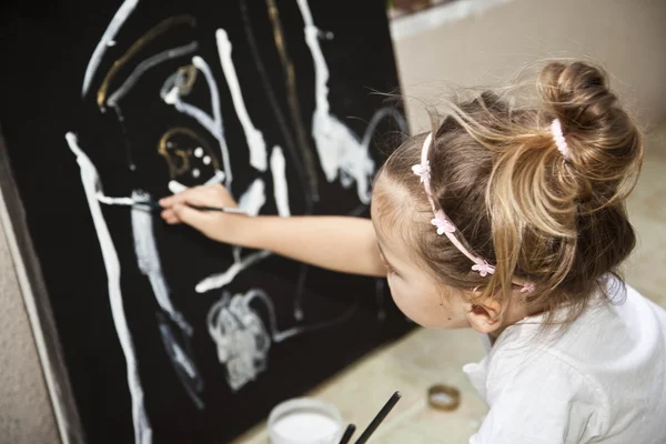 Маленькая девочка рисует картину акриловые — стоковое фото