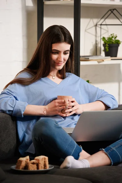 Женщина Чашечкой Кофе Используя Ноутбук Диване Себя Дома — стоковое фото