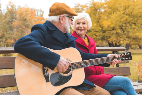 Старший пара с гитарой в парке — стоковое фото