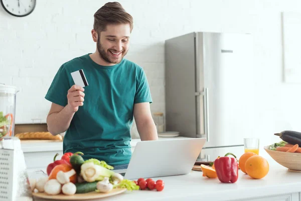 Улыбающийся Человек Кредитной Карты Ноутбук Покупки Товаров Онлайн Кухне Дому — стоковое фото