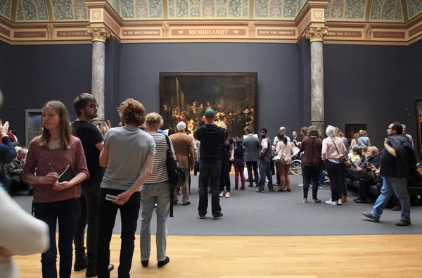 Посетителей, глядя на знаменитый Ночной дозор, Рембрандта, Ams — стоковое фото