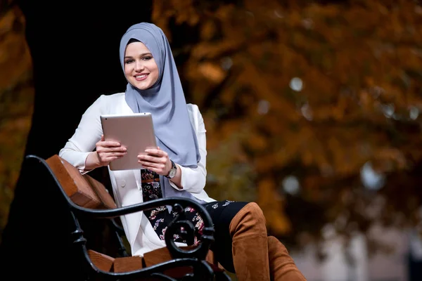 Красивая Молодая Девушка Носить Хиджаб Используя Таблетки Скамейке Парке Осенние — стоковое фото